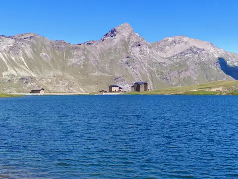 Il Lago Miserin con il santuario e il rifugio sulla riva opposta, sotto le creste della conca