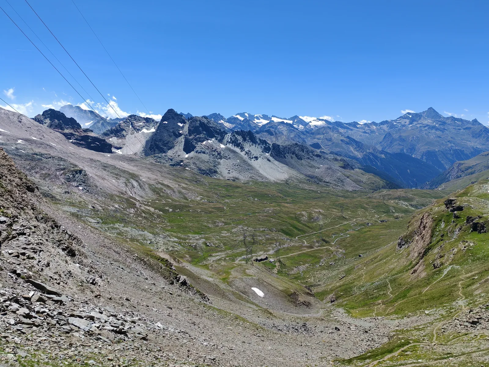 Il panorama dalla Finestra di Champorcher verso il vallone dell'Urtier, con i tralicci, le creste rocciose e i ghiacciai del Gran Paradiso in fondo