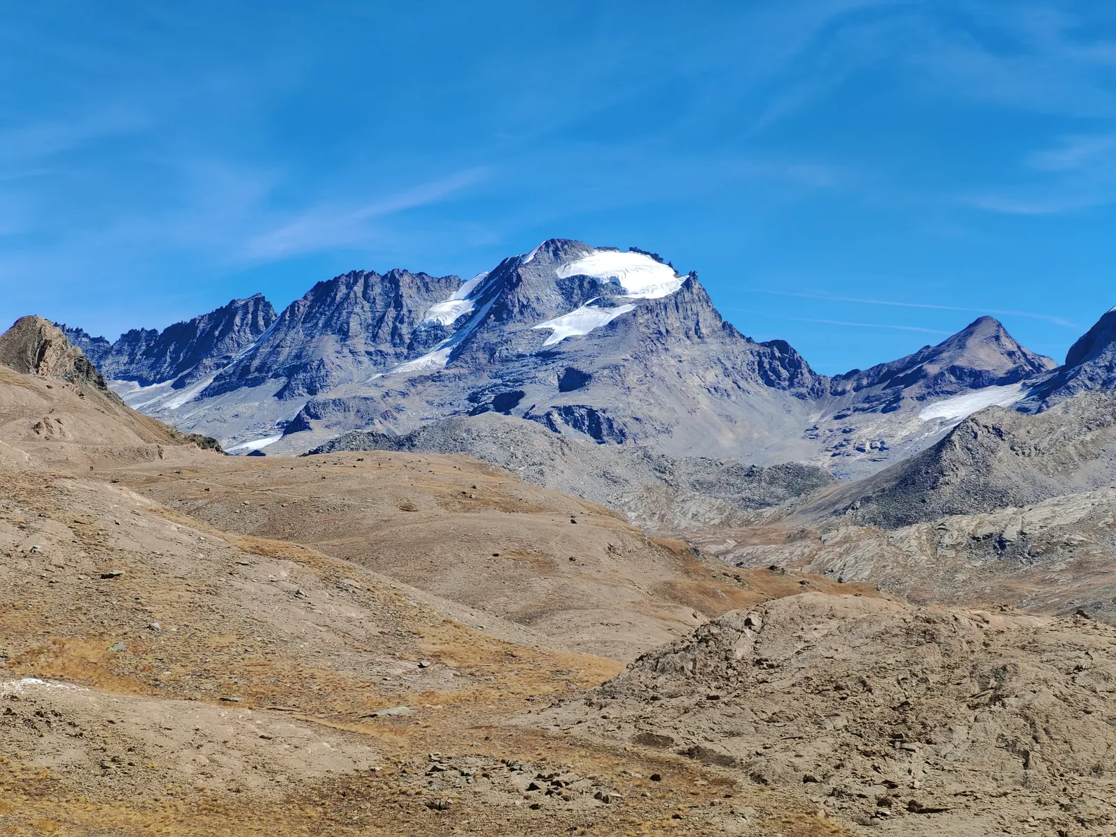 Il massiccio del Gran Paradiso con la calotta glaciale sommitale, visto dall'altopiano attraverso le praterie ocra di fine settembre