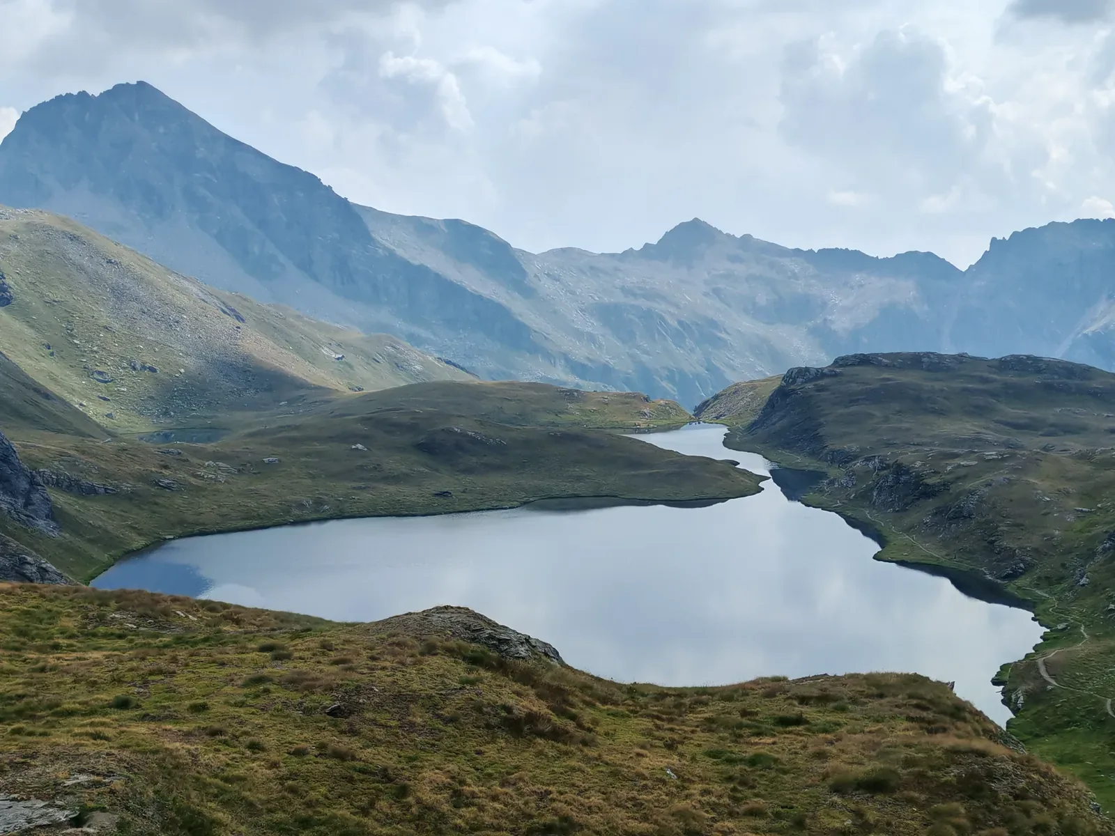 Il Lago della Battaglia visto dall'alto, allungato fra i dossi erbosi e stretto al centro da un promontorio