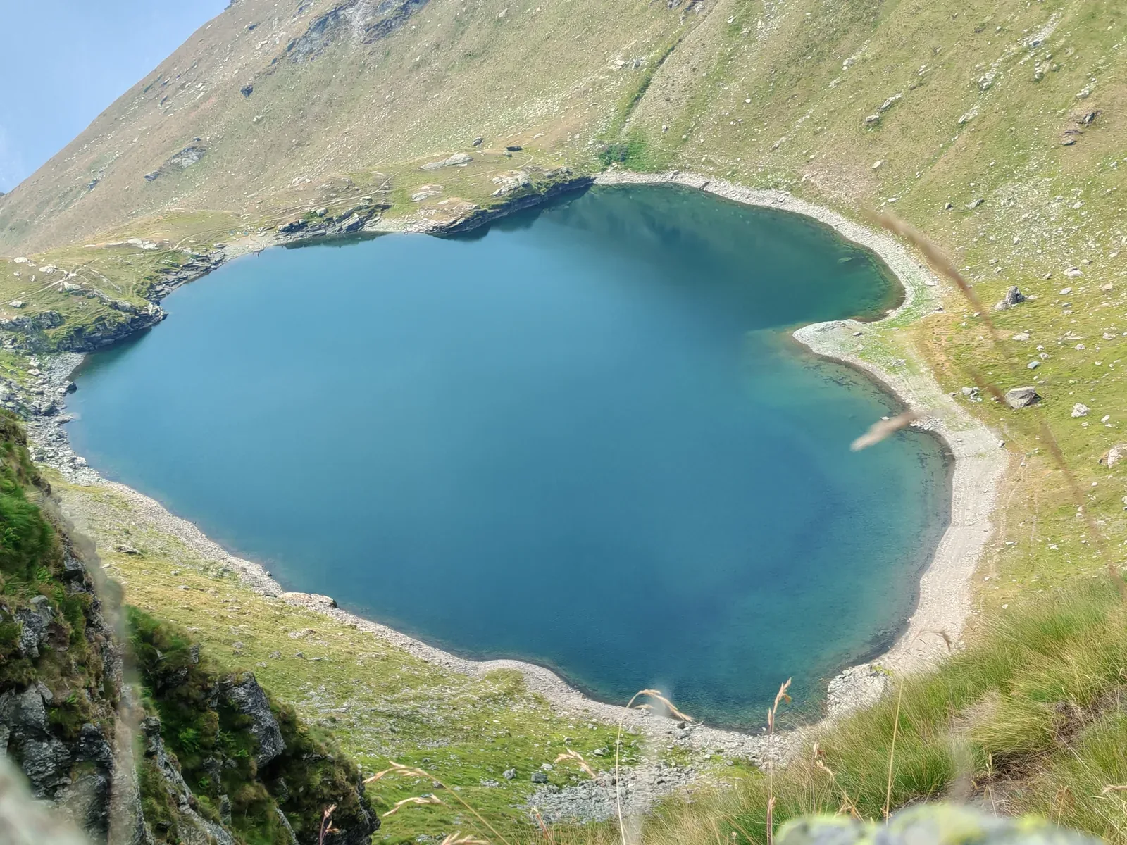 Il Lago di Bringuez visto dall'alto durante la salita al colle: acqua blu profondo in una conca chiusa