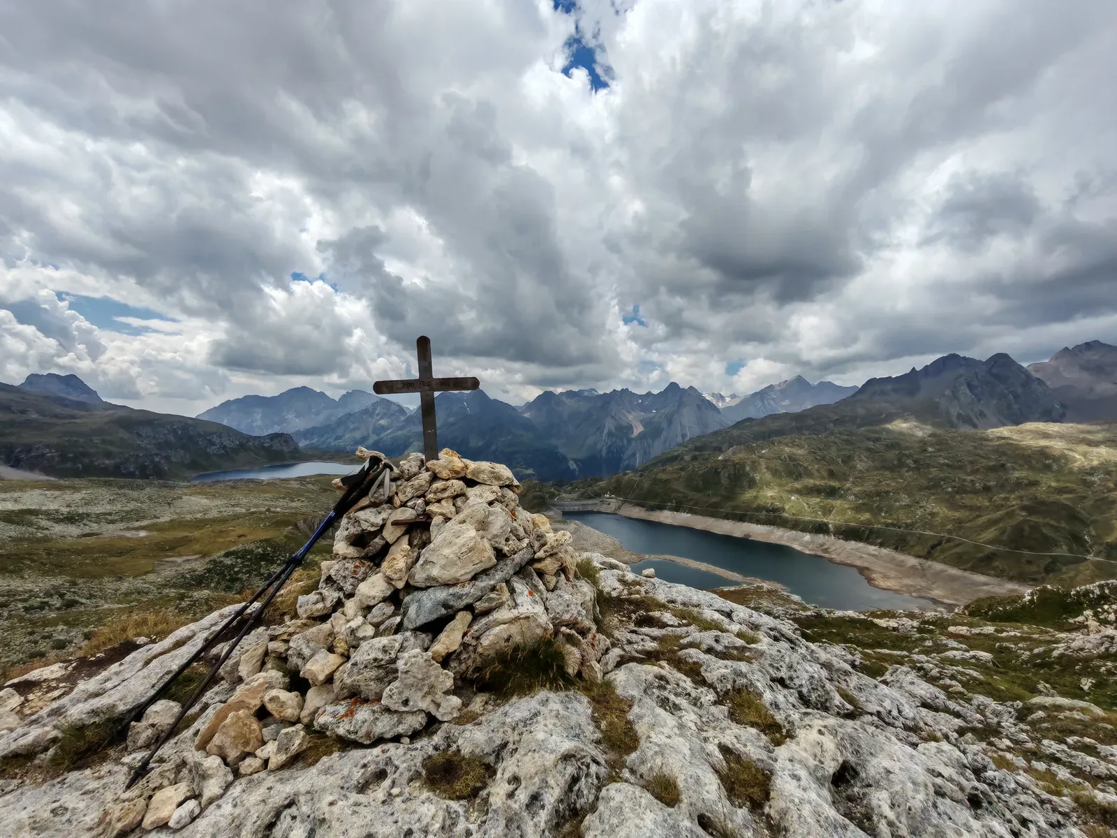 L'ometto di pietre chiare con la croce di legno sulla Rupe del Gesso, e sotto il Lago Kastel e il Lago Toggia