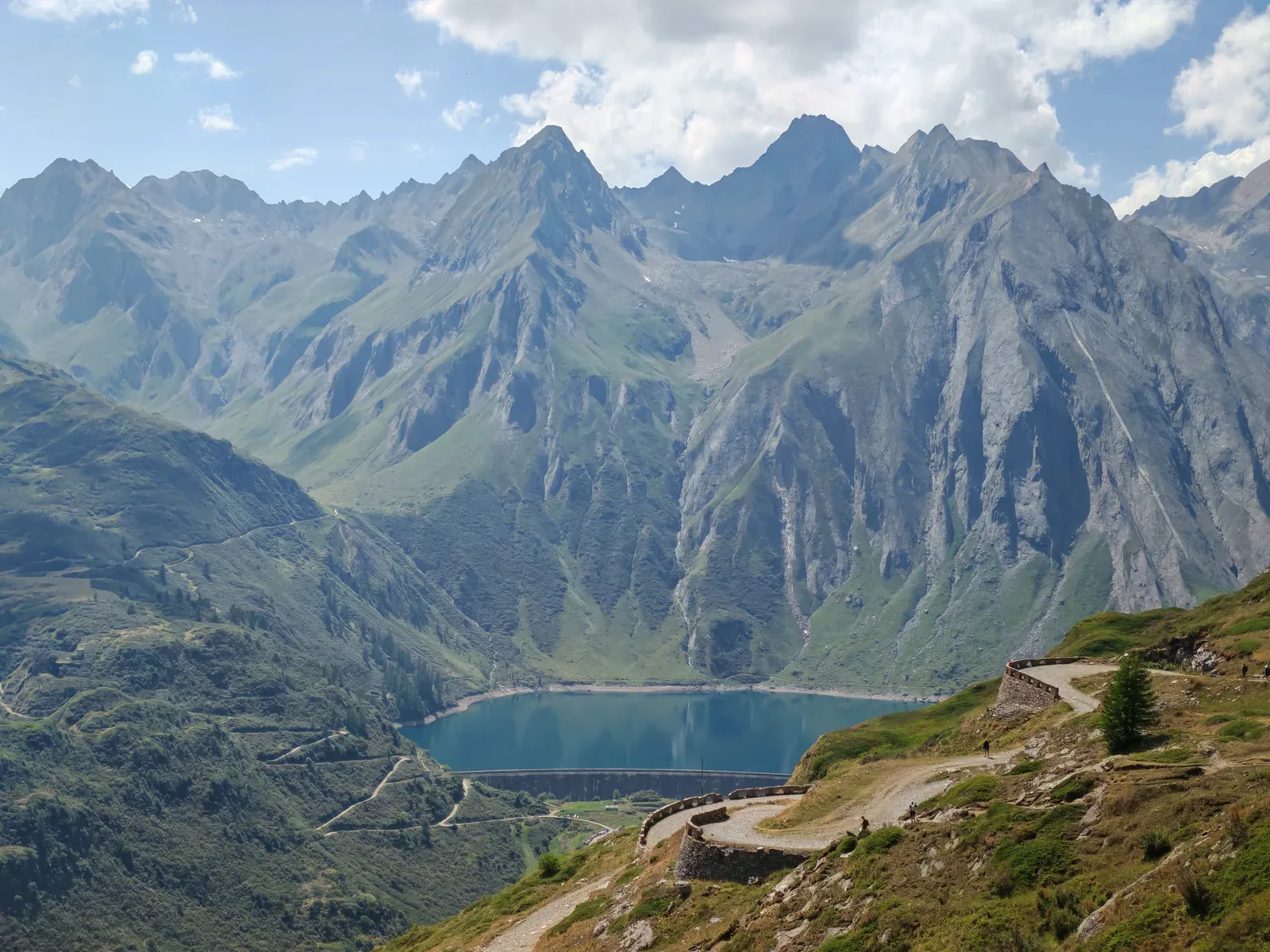La strada del Passo San Giacomo con il parapetto in pietra a secco che scende a tornanti sopra il Lago Morasco